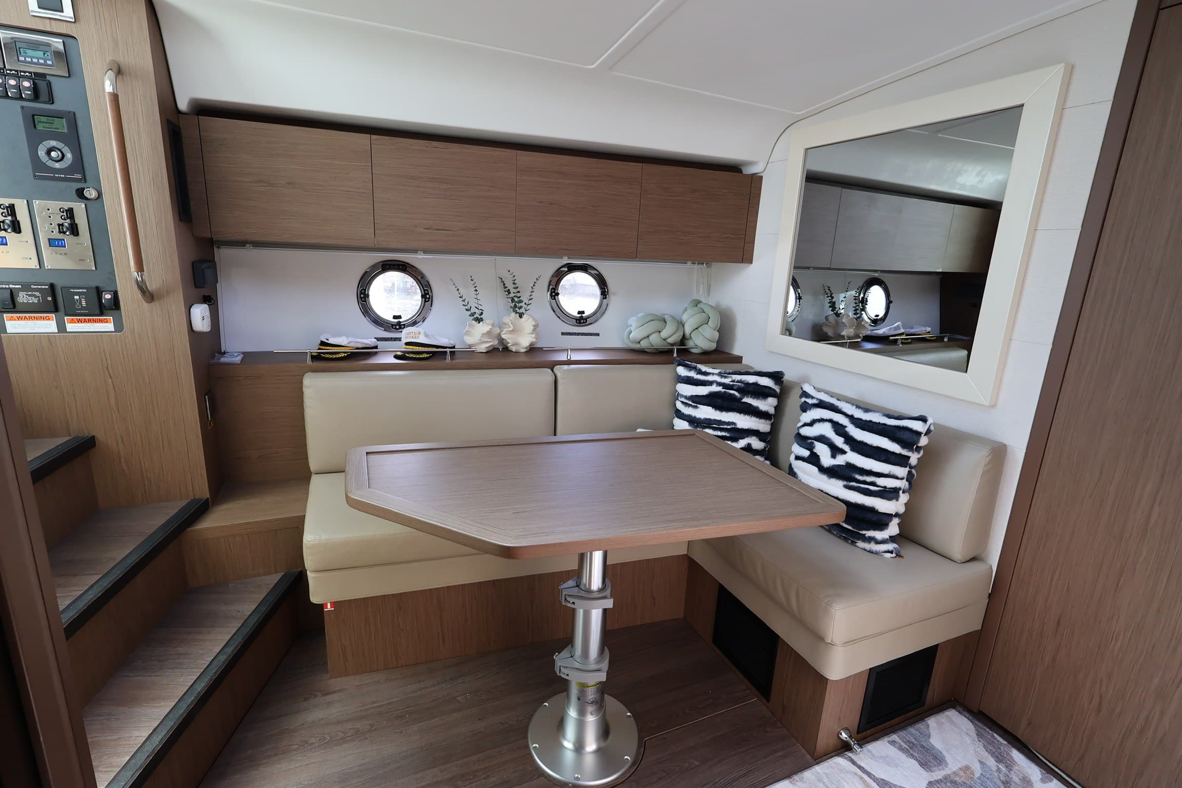 The cabin dinette with oak cabinetry and twin portholes